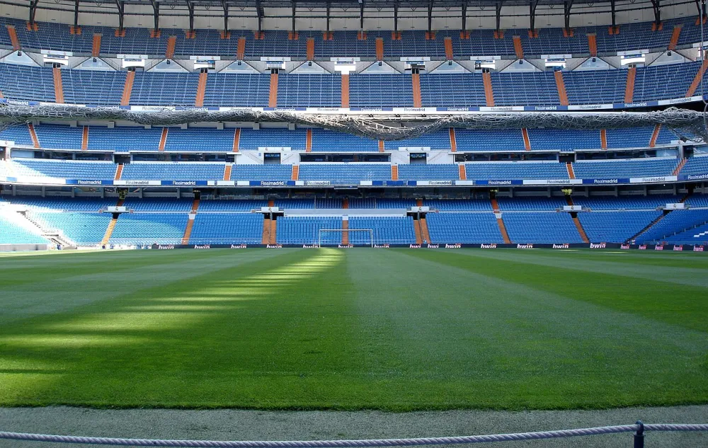 El terreno de juego del Santiago Bernabéu a pie de campo, junto a la zona de banquillos